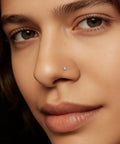 Close-up of Implant Grade Titanium Nose Stud 20G with Dope Cubic Zirconia Sparkle on model's nostril, perfect for sensitive skin.