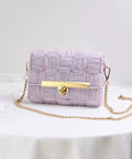 Front view of lavender woven purse with gold-tone turn-lock clasp and chain strap.