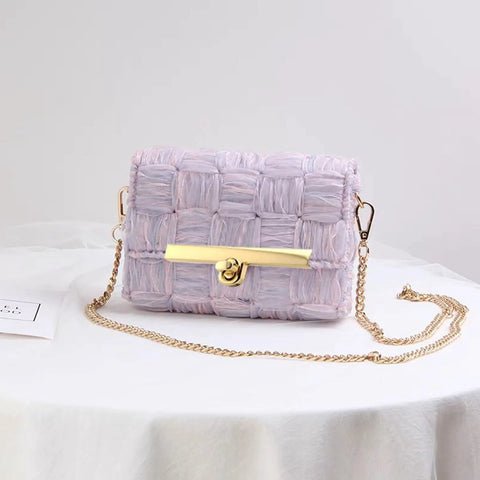 Front view of lavender woven purse with gold-tone turn-lock clasp and chain strap.
