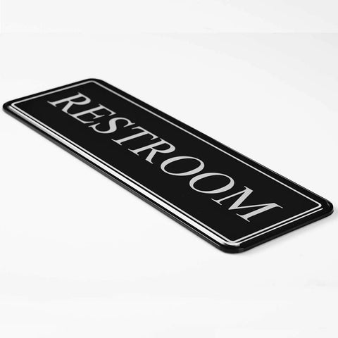 Premium Restroom Sign 9x3 Acrylic With Double Sided 3M Tape HD UV Print Bright Black Background Easy To Find No Fuss Restroom Recognition In Hotels Cafes And Offices, angled view.
