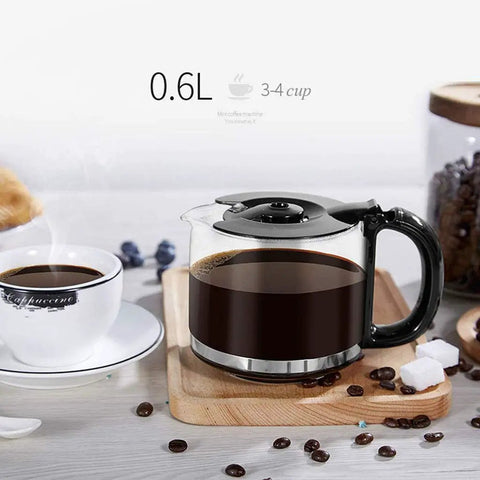 Hassle Free Mini Coffee Maker With Built In Bean Grinder And Glass Carafe, Solid Six Cup Drip Brewer featuring a glass carafe with brewed coffee.