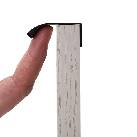 Close-up of black aluminum edge pull handle with concealed tab, part of 10 Pack Black Aluminum Edge Pull Handles Hidden Concealed Tab Pulls For Doors Drawers Cabinets Wardrobes Sleek 80mm And 3.2 Inch Finger Pulls Durable Modern Hardware For Home, being held by finger on wood surface.