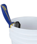 Gum Rubber Margin Float 6 Inch By 2 Inch With Comfort Grip Handle resting on white bucket edge, showing steel backing and handle design.
