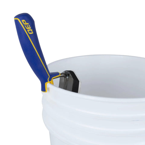Gum Rubber Margin Float 6 Inch By 2 Inch With Comfort Grip Handle resting on white bucket edge, showing steel backing and handle design.