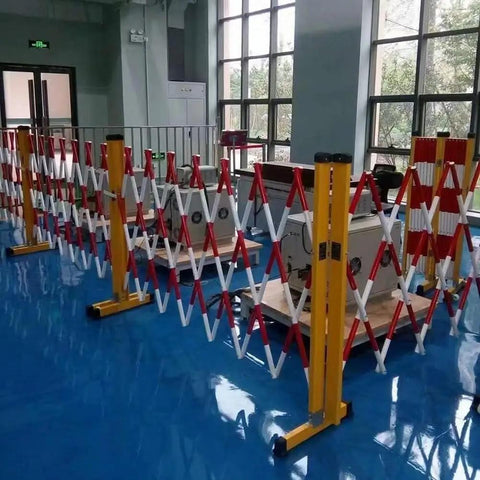 Adjustable Telescopic Safety Barrier With Slick Glide Casters set up indoors, showing red and white retractable panels and casters.