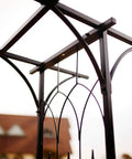 Top view of steel garden arch showing black epoxy finish, 6 ft 9 in high by 4 ft 11 in wide, ideal for climbing plants and flowers.