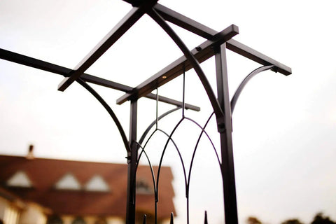 Top view of steel garden arch showing black epoxy finish, 6 ft 9 in high by 4 ft 11 in wide, ideal for climbing plants and flowers.