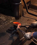 Craftsman forging Long Handle Scythe With Double Edged Aogami No 2 Steel Blade for forestry and gardening tasks, red hot steel.