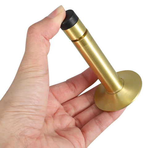 Hand holding a gold-colored Sleek Wall Mounted Door Stop With No Drilling Easy Install Adjustable Length 1.1 Inch Silent Hydraulic Stopper For Home And Office Durable Aluminum Alloy Keeps Doors Quiet And Safe