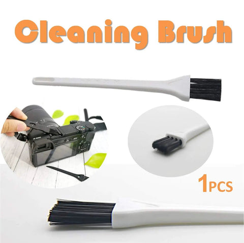 Close-up of cleaning brush with black bristles next to camera, 1-piece, for cleaning electronic devices.
