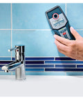 Heavy Duty Digital Stud Finder Wall Scanner With Killer Precision Detection For Wood Copper Pipes Metal And PVC Cavity Scan in hand near faucet.