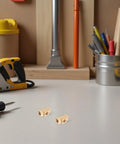 Brass 3 Way Tee Fitting For Pneumatic Systems, 4 Pack, Threaded Pipe Tee Connector on a workbench with tools