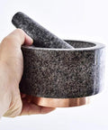 Hand holding Marble Mortar And Pestle Set With Brass Base For Guacamole Herbs Garlic And Spices Large Stone Grinder Easy To Clean