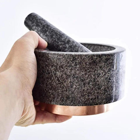 Hand holding Marble Mortar And Pestle Set With Brass Base For Guacamole Herbs Garlic And Spices Large Stone Grinder Easy To Clean