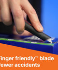 Slice 10513 pen cutter with black handle and white blade cutting a blue cardboard box
