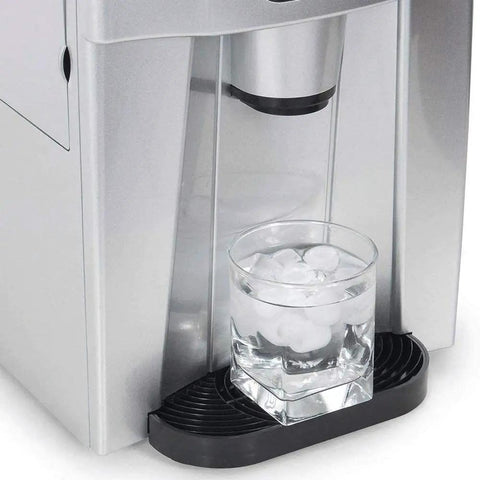 Zero Drama Automatic Countertop Ice Machine Cranking Out Fresh Clear Cubes At Nine Point Five Kilograms Daily With Food Grade Abs Body And Sleek Brushed Metal Finish For Instant Home Bar Ready Vibes, glass filled with ice under dispenser.