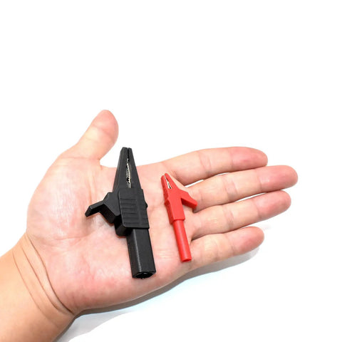 Hand holding large and small alligator clips from the All In One 10Pcs Test Leads Kit With Double Insulated Leads, 1000V CAT III, 14AWG.