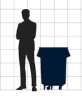Silhouette of a person standing next to a 55 Gallon Black Round Commercial Trash Can With Lid And Dolly Built Tough Heavy Duty Food Grade NSF Certified