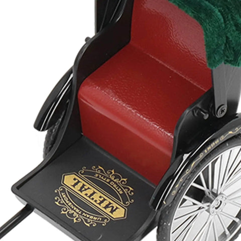 Close-up of vintage red zinc alloy rickshaw model toy's seat and detailed black frame. Perfect for desk decor.