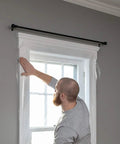 Person installing Indoor Window Shrink Film Insulation Kit For Five Windows 62 Inch By 210 Inch Crystal Clear Film.
