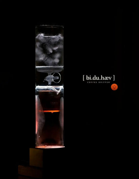 Premium Cold Brew Coffee Maker System Hits Different With Smooth Zero Bitter Hit Cold Drip Tap For Iced Coffee Tea Wine And Sake Featuring Award Winning Design Perfect For Home Bars And Weekend Kickbacks, showcasing a clear glass coffee dripper.