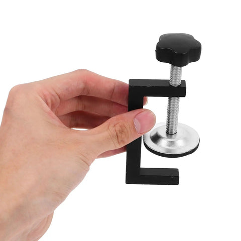 Close-up of a hand holding one of the Two Pack Adjustable Outdoor Furniture Clips That Keep Your Sofa From Sliding On Patio Wicker Chairs