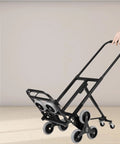 Stair Climbing Folding Cart Hand Truck With Heavy Duty Carbon Steel Frame And Rubber Wheels, black stair-climbing cart folded on floor