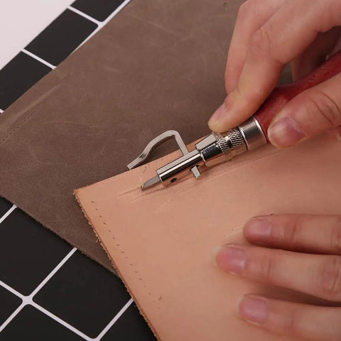 Using 7 In 1 Pro Adjustable Stitching Groover Kit for leathercraft on tan leather, detailing grooves with precision tool.
