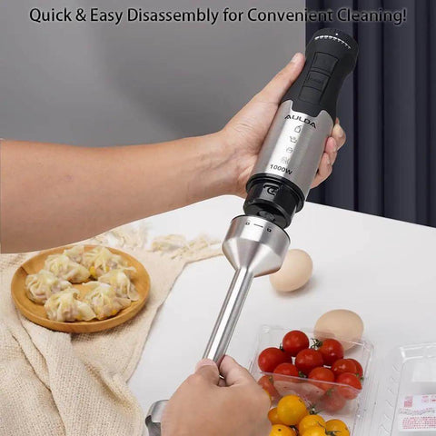 Heavy Duty 1000W Immersion Blender With 20 Speed Settings ergonomic grip held by hand, silver and black design, kitchen setting