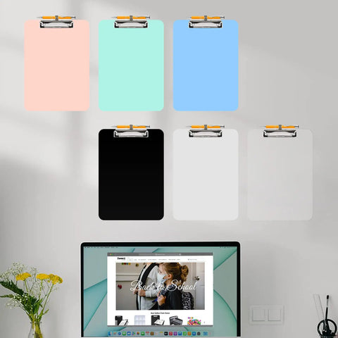 Assorted color plastic clipboards with pen holders, 8.5 by 11 size, hanging on wall; includes focus keyword "Plastic Clipboard With Pen Holder Two Pack 8.5 By 11 Standard Letter Size Low Profile Clip Sturdy Ten Percent Thicker Waterproof Hanging Clipboard For Teachers Office School Supplies" visibly displayed.