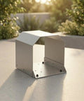 Heavy Duty Grey Foot Switch Guard Cover With Angled Hooded Shape And Textured Coating For Tight Machine Shop Spaces Durable Hardware Accessory on a table.