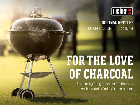 Original Kettle Charcoal Grill 22-Inch Black with One-Touch Cleaning System on grass with steam rising