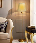 Elegant floor lamp with white shade beside beige sofa in modern living room