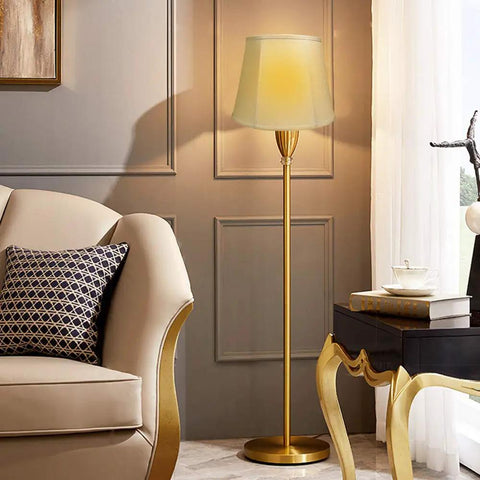Elegant floor lamp with white shade beside beige sofa in modern living room
