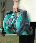 Pretty Slick Portable Garden Hose Reel With High Pressure Water Gun, No Tangle Wall Mount Storage Rack, Grab And Go Carry Handle shown being carried.
