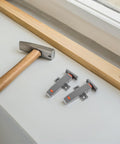 Heavy Duty Cabinet Door Push Latch 2 Pack, Adjustable Rebound Tension Self Closing Touch Catch next to a hammer
