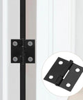 Close-up of a solid black one inch metal hinge installed on a white cabinet door, part of a 24 Pack Of Solid Black One Inch Metal Hinges With Included Fasteners Quick Hook Up For Drawers Cabinets And Small Craft Boxes Built Tough For Heavy Duty Jobs.