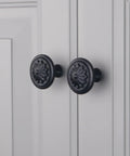 Matte Black Round Cabinet Knobs 10 Pack Zinc Alloy With Floral Design 1.4 Inch Diameter Drawer Knobs With Included Screws For Cabinets And Dressers Dope Hardware To Level Up Your Furniture on a white cabinet