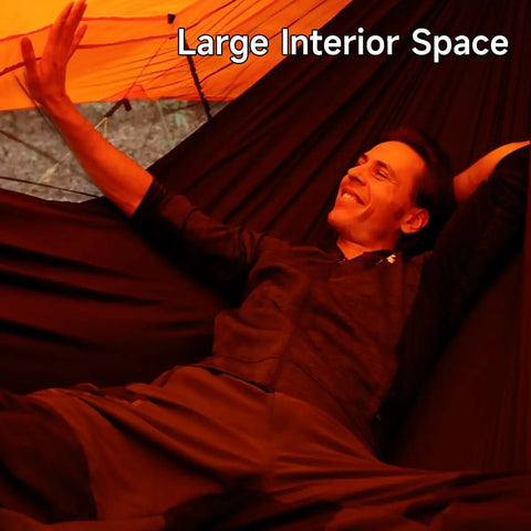 Man relaxing inside UltraLight 11 Ft Hammock Shelter With Net And Rain Fly Tarp Four In One Camping Tent, showing spacious interior