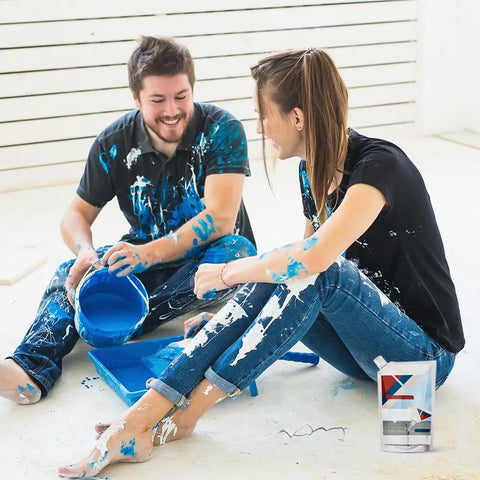 Smiling couple painting room, holding blue paint bucket with Heavy Duty Concrete Crack Filler and Repair Adhesive Black 200G nearby.