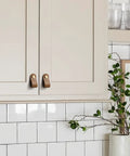 Brown Leather Drawer Pulls 6 Pack For Kitchen Cabinets And Drawers installed on cream cabinet doors in a modern kitchen