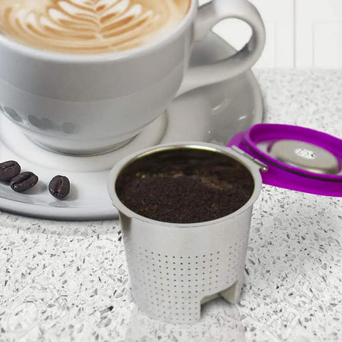 Stainless Steel Reusable K Cup Coffee Pod With Built In Filter For Keurig Single Serve Brewers on countertop near coffee mug
