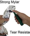 Hands testing tear resistance of Emergency Survival Sleeping Bags 2 Pack For Cold Weather Camping And Outdoor Rescue Mylar Thermal Bivy Sack
