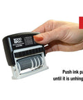 Hand holding a Slick Self Inking Micro Message Dater Stamp With Quick Flip Phrases, showing the ink pad mechanism and phrases.