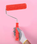 Rubber Texture Paint Roller For Easy Peasy Wall Embossing And Quick Home Reno Makeovers That Deck Out Your Space With Knockout Decorative Finishes And Zero Stress, held in hand with a patterned red rubber head.