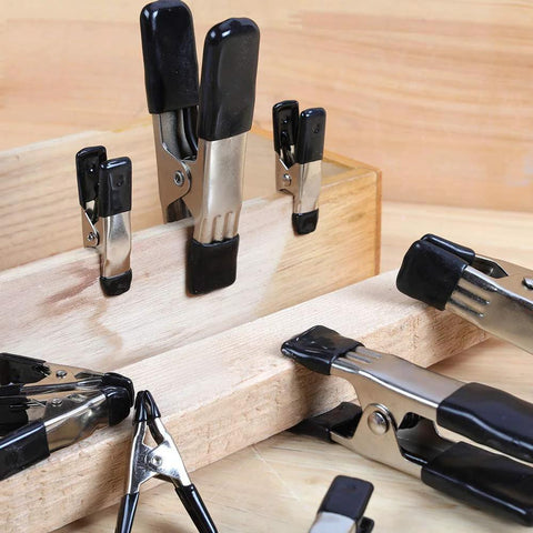 Amazon Basics steel spring clamps set with black PVC-coated tips; assorted 3/4-in and 1-in clamps on wood