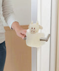 Woman using Anti Collision Door Stopper Wall Protector And Door Bumper For Home Use on metal handle, soft cushion animal design.