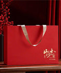 Red gift box with gold detailing and beige handle, displaying a decorative design, ideal for storing or presenting items.