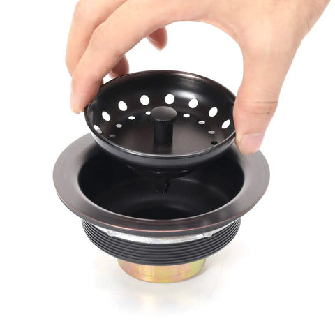 Hand holding strainer basket of Three And A Half Inch Kitchen Sink Drain Assembly With Strainer Basket And Stopper, Oil Rubbed Bronze, All Stainless Steel, Rustproof And Built To Last For Heavy Use
