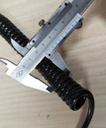 Caliper measuring diameter of 12 Core Industrial Spring Spiral Coiled Cable for CNC Handheld Encoder MPG on wooden surface.